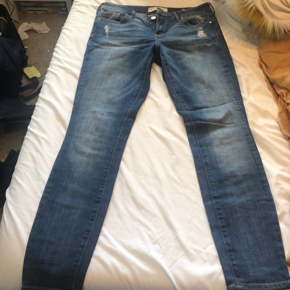 Denim jeans distressed at top and back pockets